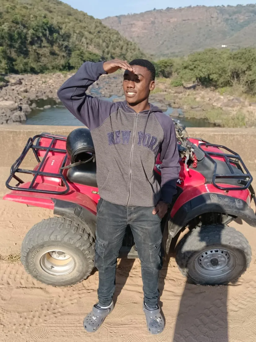 A rider standing beside his quad with Inanda Dam behind him